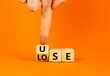 Use or lose symbol. Concept words Use or lose on wooden cubes. Businessman hand. Beautiful orange table orange background. Business Use or lose concept. Copy space.