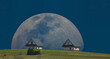 Rise of the moon behind small houses