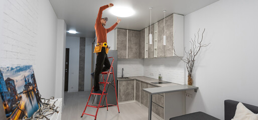 Wall Mural - Electrician repairing ceiling fan with lamps indoors. Space for text.