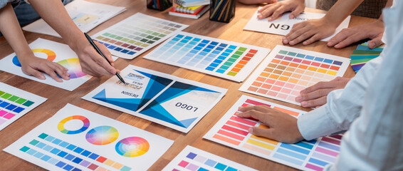 Leinwandbilder - Graphic designer brainstorm logo and graphic art at busy creative studio workshop. Experiment and brainstorm color palette and pattern at workspace table for creative design. Panorama shot. Scrutinize