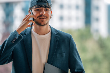 Wall Mural - attractive student talking on mobile phone in the street