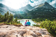 © Michael - Young sportive couple enjoys view on the turquoise Sorapis lake from a beautiful restpoint in the afternoon. Lake Sorapis, Dolomites, Belluno, Italy, Europe.
