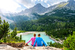 © Michael - Young sportive couple enjoys view on the turquoise Sorapis lake from a beautiful restpoint in the afternoon. Lake Sorapis, Dolomites, Belluno, Italy, Europe.