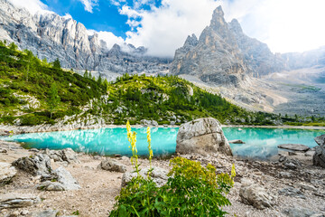 Beautiful view on turquoise Sorapis lake and with dito di dio in the background in the evening. Lake Sorapis, Dolomites, Belluno, Italy, Europe.