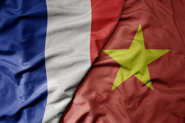 big waving realistic national colorful flag of france and national flag of vietnam .