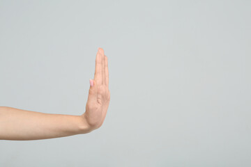 Wall Mural - Woman showing stop gesture on light grey background, closeup. Space for text