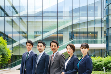 Fototapete - オフィスビルの前に並ぶエグゼクティブ男女ビジネスパーソンのグループ