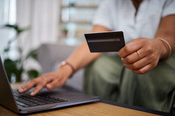 Poster - Woman, laptop and hands with credit card in ecommerce, payment or fintech banking on sofa at home. Closeup female person or shopper with debit on computer app in online shopping, purchase or buying