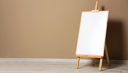 Wooden easel with blank board near beige wall indoors. Space for text