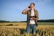 © Serhii - Farmer examining crops crouching in wheat farm