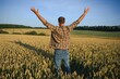 Happy farmer proudly standing in wheat field. Rich harvest of cultivated cereal crop.