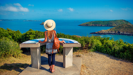 Wall Mural - Woman tourist enjoying panoramic view of breton coast and island- Brittany in France