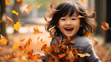 Cute Asian Child Playing With Autumn Leaves In The Park 