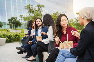 Wall Mural - Business people doing lunch break with healthy fast food outdoor from office building - Colleagues day lifestyle and food concept concept - Focus on asian girl face