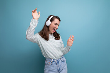 Canvas Print - dancing 25 year old brunette woman in a shirt and jeans enjoys music in headphones