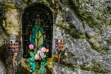 Wayside Shrine With Flowers And Candles In A Rocky Wall During Hiking