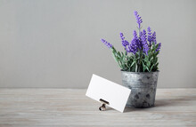 Blank White Business Card And Tin Bucket With Artificial Lavender. Copy Space For Your Text.