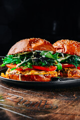 Wall Mural - two beef burgers with vegetables on dark background