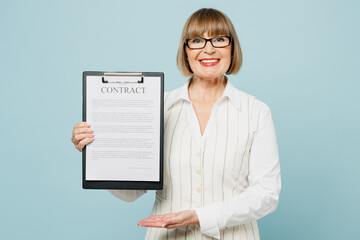 Wall Mural - Employee business woman 50s wear white classic suit glasses formal clothes hold clipboard with paper document contract agreement isolated on plain pastel blue background. Achievement career concept.