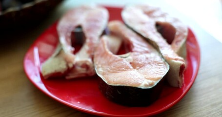 Wall Mural - Raw pieces of red salmon fish lying on plate closeup 4k movie slow motion. Healthy lifestyle proper nutrition concept