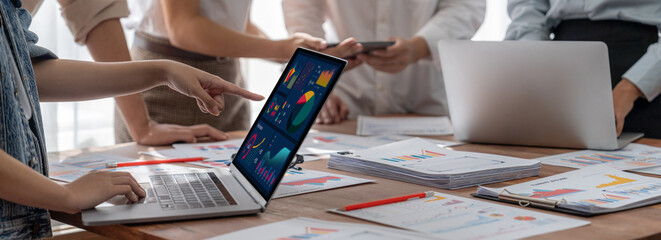 Fototapete - Panorama shot analyst team utilizing BI Fintech to analyze financial report with laptop. Businesspeople analyzing BI power dashboard displayed on laptop screen for business insight. Scrutinize