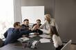 © fizkes - Happy business team giving group high five, celebrating achievement, win, corporate education success, successful project startup, laughing, sitting at meeting table in boardroom