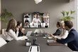 Leinwandbild Motiv Business teem of office employees and freelancers meeting on online video chat, conference call. Coworkers sitting at negotiation table, looking at display with speaking distance colleagues