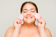 Excited fat woman exfoliating her skin with sponges