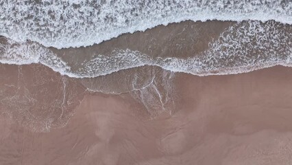 Poster - high angle view of wave pattern as it hits the shore