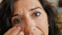 Middle Age Hispanic Woman Touching Baggy Eyes At Home