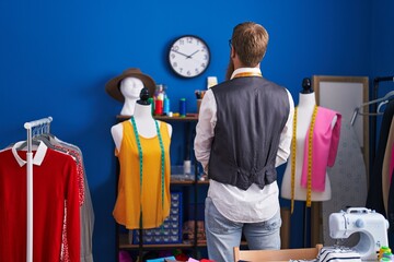 Poster - Young redhead man tailor standing on back view at clothing factory