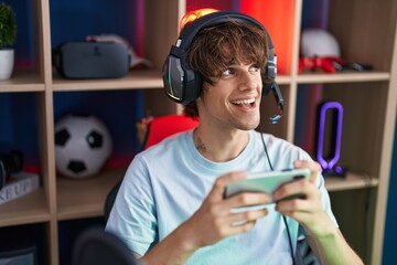 Poster - Young blond man streamer playing video game using smartphone at gaming room