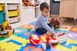 © Krakenimages.com - Adorable hispanic boy playing supermarket game sitting on floor at kindergarten