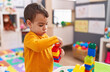 © Krakenimages.com - Adorable hispanic boy playing with construction blocks standing at kindergarten