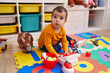 © Krakenimages.com - Adorable hispanic boy playing supermarket game sitting on floor at kindergarten