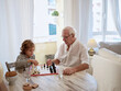 Elderly man teaching boy to play chess