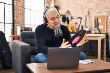 Sticker - Middle age grey-haired man musician listening to music holding vinyl disc at music studio