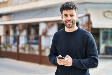 Poster - Young arab man smiling confident using smartphone at street