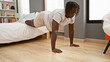 © Krakenimages.com - African american man training push up at bedroom