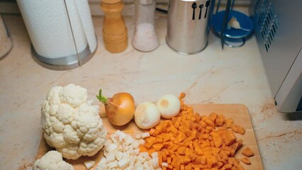 Wall Mural - Chopped vegetables, carrot in kitchen, cutting board. White carrot.