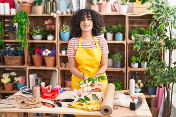 Poster - Young middle eastern woman florist make bouquet of flowers at florist