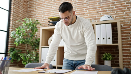 Wall Mural - Young hispanic man business worker reading document at office