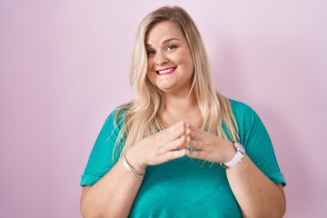 Poster - Caucasian plus size woman standing over pink background hands together and fingers crossed smiling relaxed and cheerful. success and optimistic