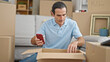 © Krakenimages.com - Middle age man unpacking cardboard box using smartphone at new home
