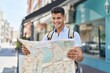 © Krakenimages.com - Young hispanic man student smiling confident holding city map at street