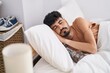 © Krakenimages.com - Young hispanic man lying on bed sleeping at bedroom