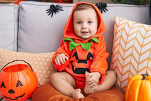 Adorable Caucasian Baby Having Halloween Party Wearing Pumpkin Costume At Home