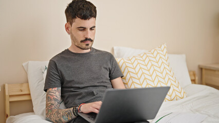 Canvas Print - Young hispanic man using laptop relaxed on bed at bedroom