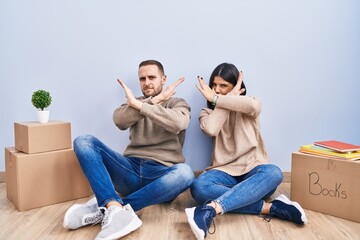 Poster - Young couple moving to a new home rejection expression crossing arms doing negative sign, angry face