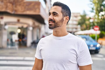 Wall Mural - Young hispanic man smiling confident standing at street